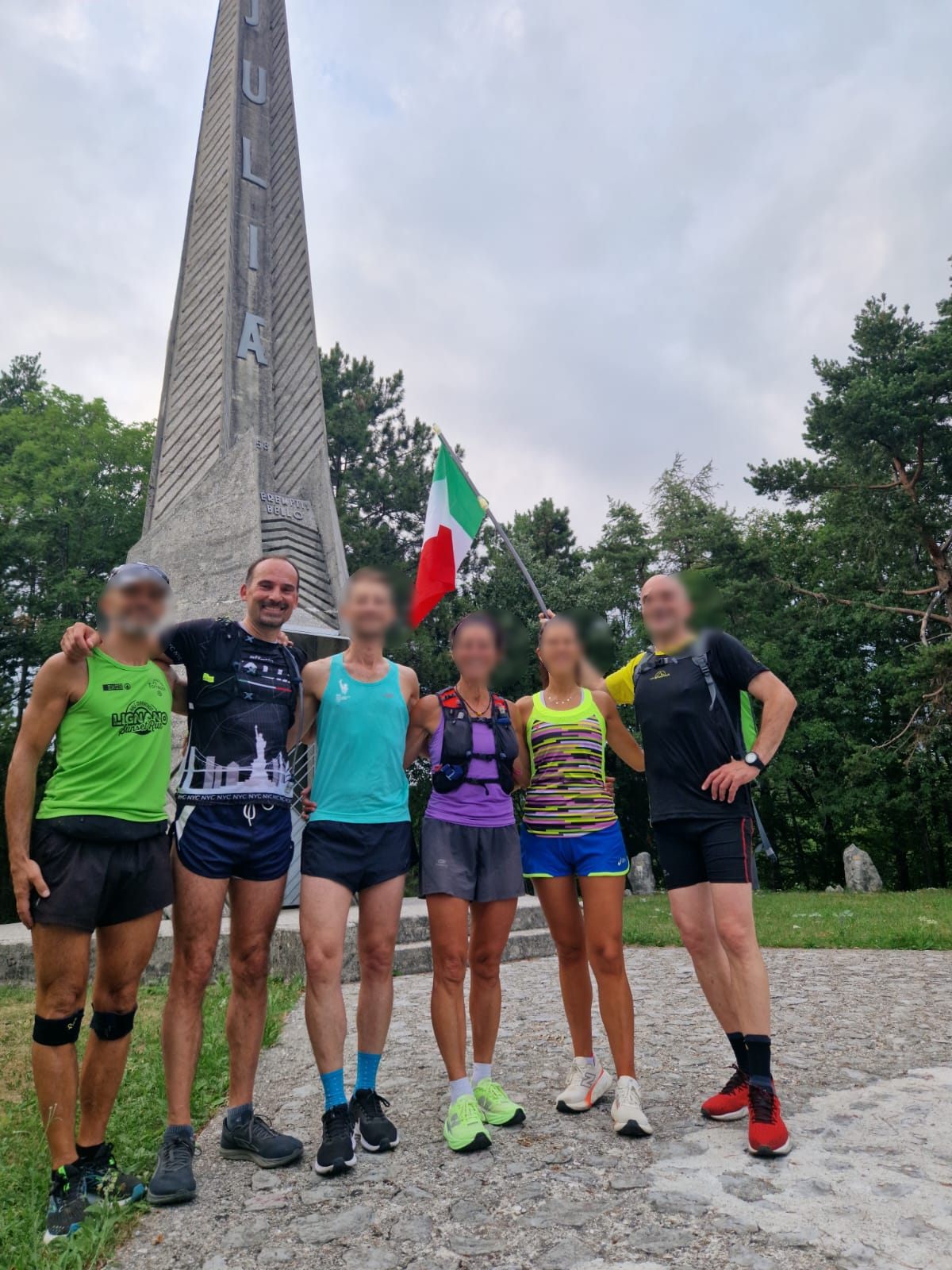 Corsa in montagna con il gruppo di amici runner davanti al monumento Julia